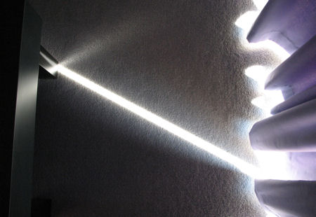 A beam of light striking through the curtains